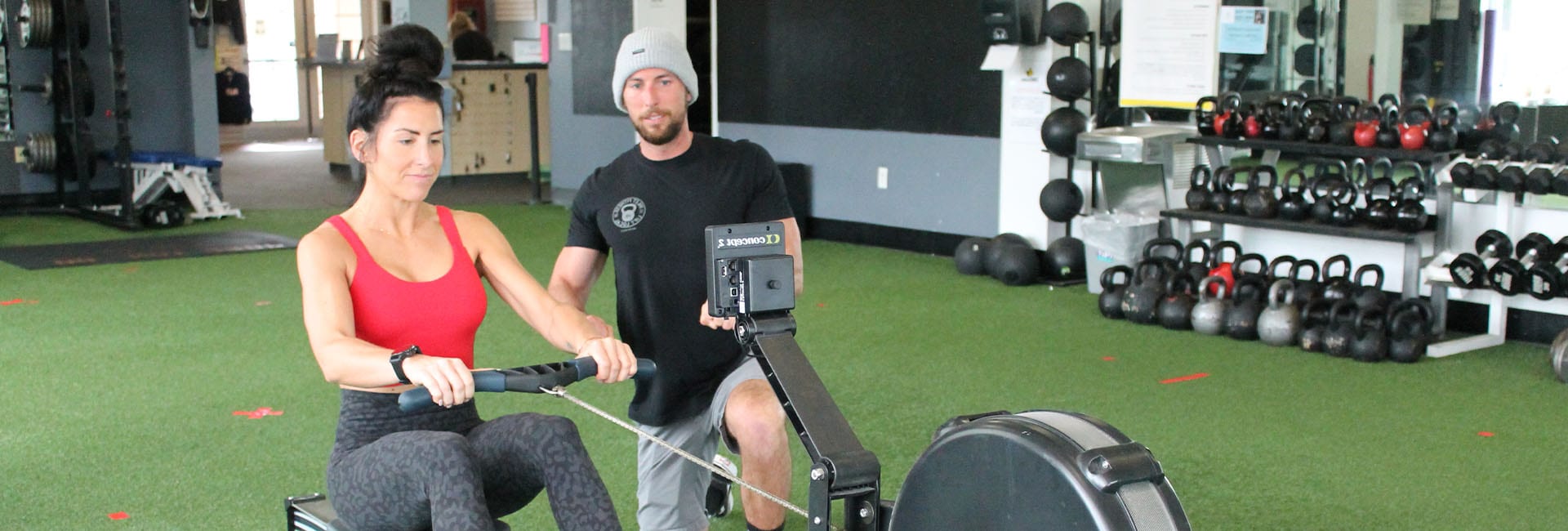 personal trainer and client on row machine