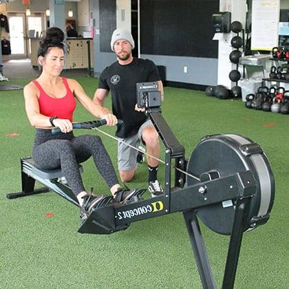 personal trainer and client on row machine