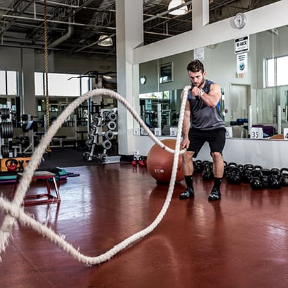 man using battle ropes to workout