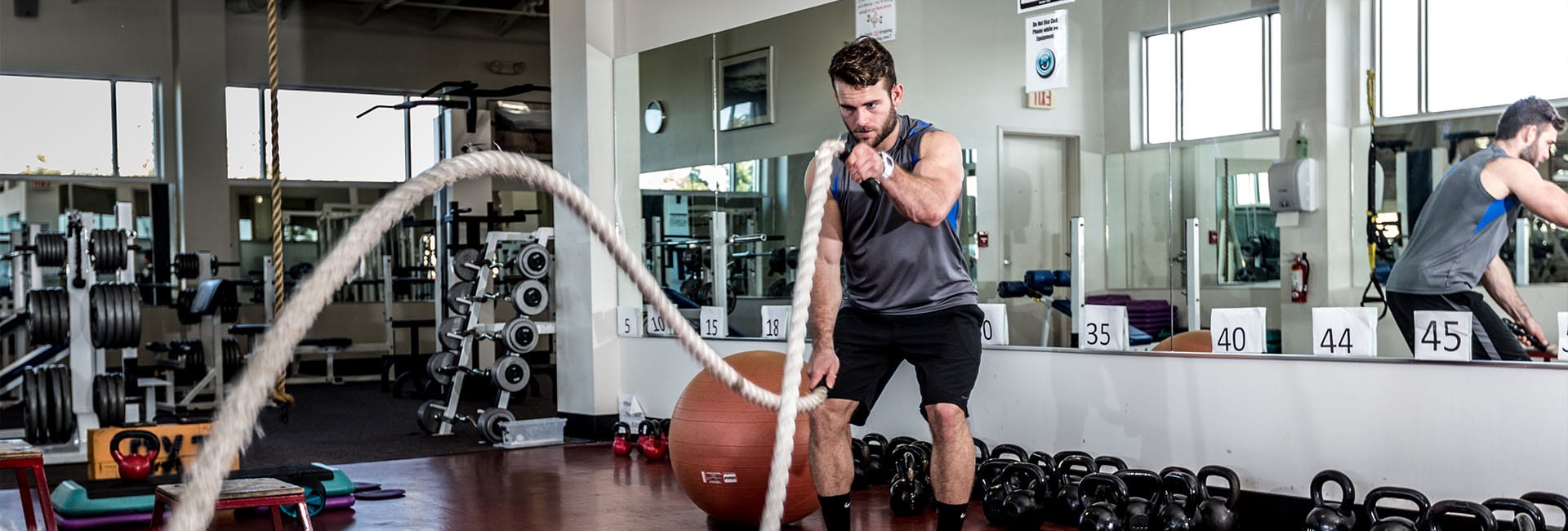 man using battle ropes to workout